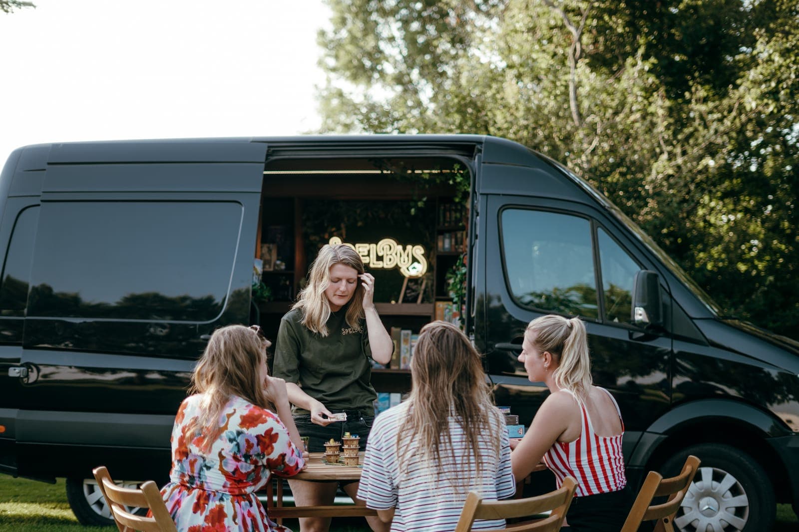 De Spelbus uitgeklapt op locatie met gasten aan tafel